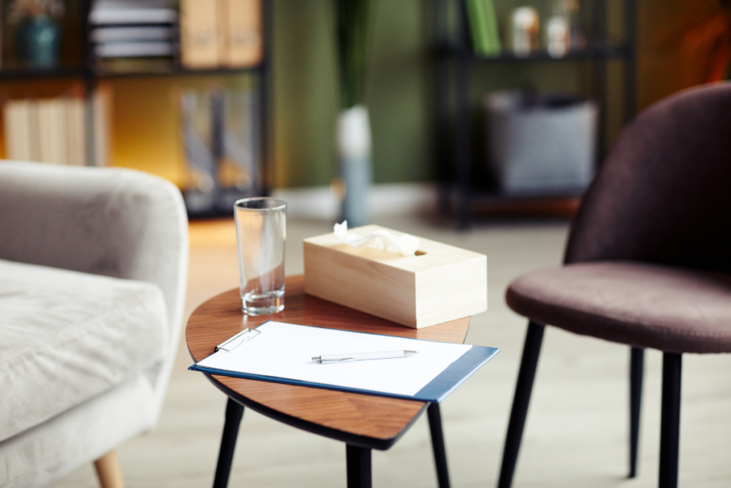 Mots-clés quand on est thérapeute : une table, un verre, un bloc notes, un crayon et une boite de mouchoirs