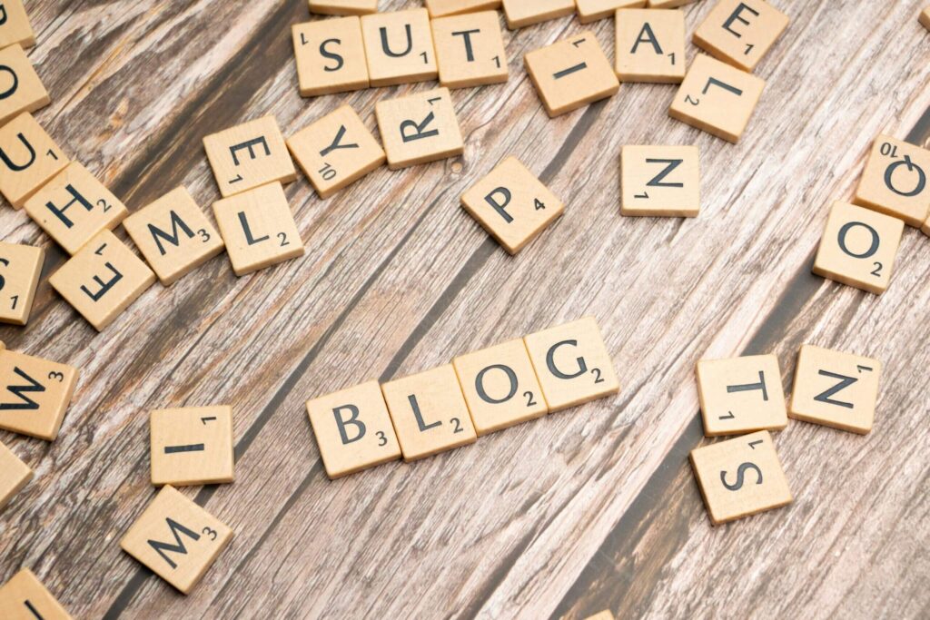 Tuiles de Scrabble posées sur une table en bois qui inscrit BLOG
